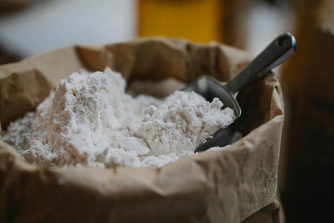 Suplemento de glutamina em pó ao lado de alimentos proteicos