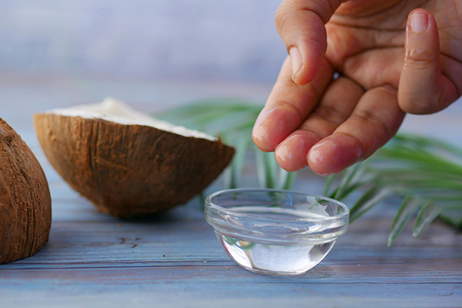 Óleo de coco em pote de vidro com coco fresco